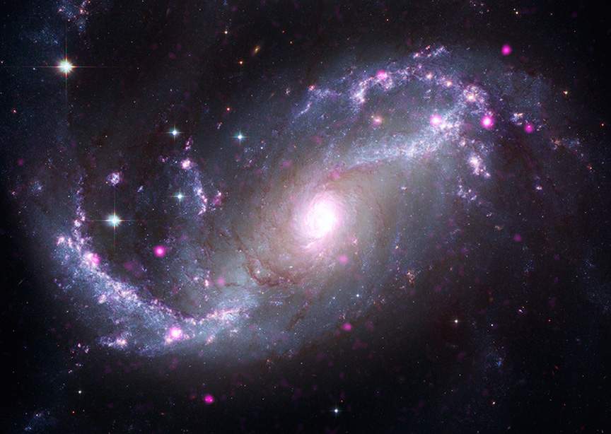 Immagine composita della galassia a spirale barrata NGC 1672 che combina i dati dei telescopi James Webb, Chandra, Hubble, Spitzer, XMM-Newton. Credits: raggi X: Chandra: NASA/CXC/SAO, XMM: ESA/XMM-Newton; IR: JWST: NASA/ESA/CSA/STScI, Spitzer: NASA/JPL/CalTech; Ottico: Hubble: NASA/ESA/STScI, ESO